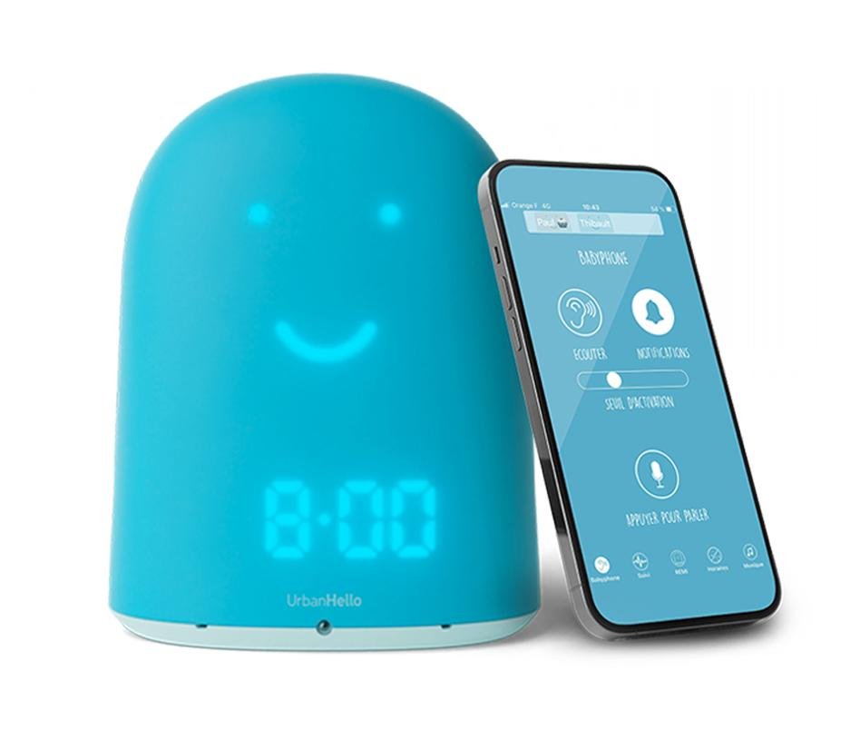 A blue sleep device with a smiling face sits next to a tilted smartphone displaying an app screen.